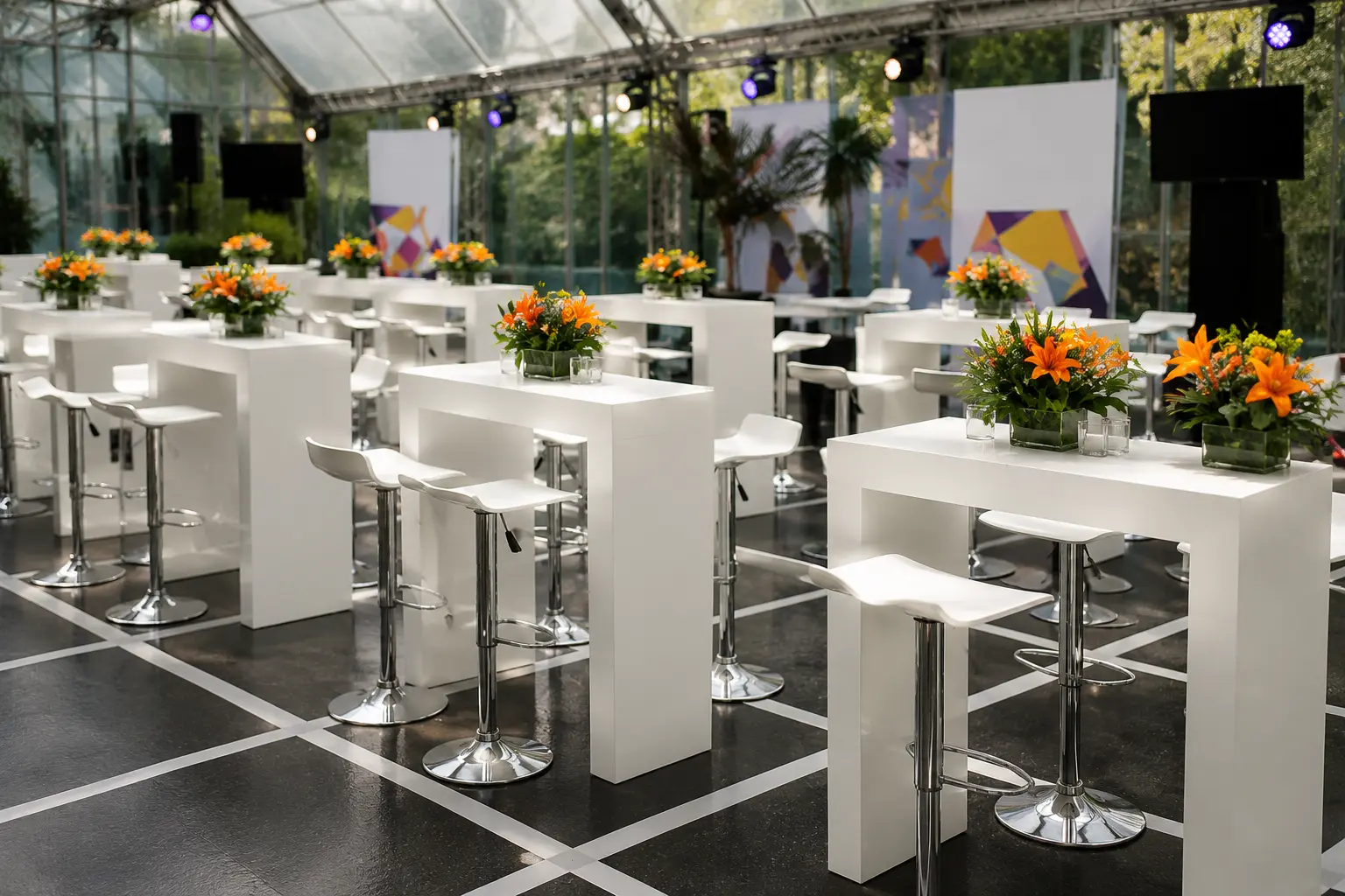 Mesas cocteleras blancas con butacos y flores en evento corporativo