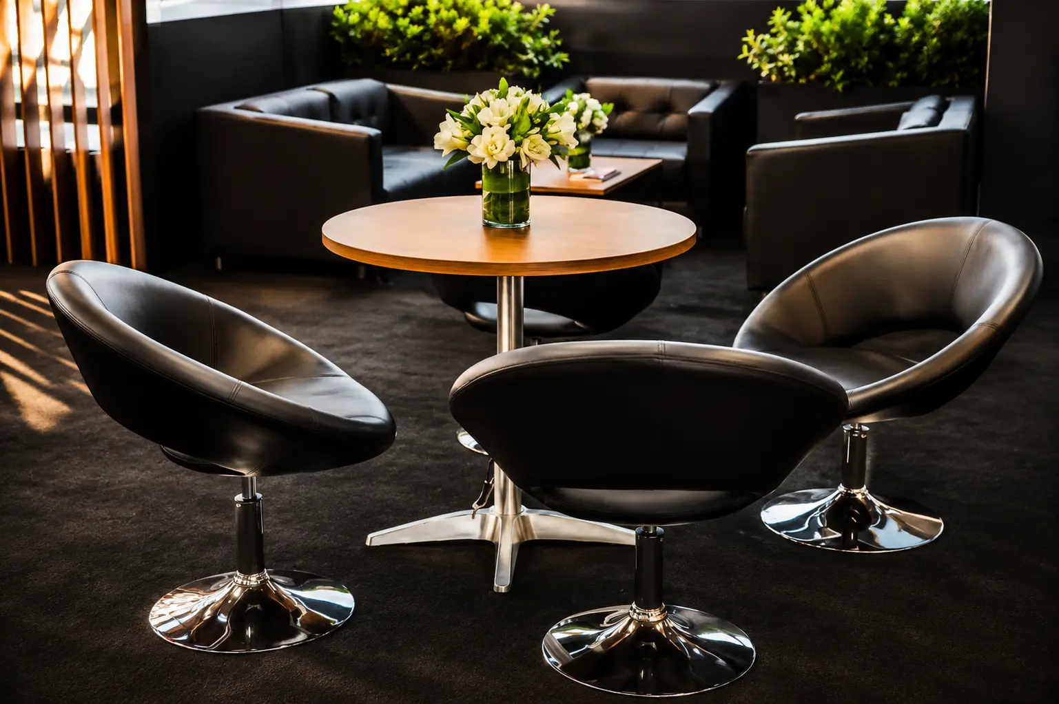 Sillas lounge de cuero negro alrededor de mesa redonda