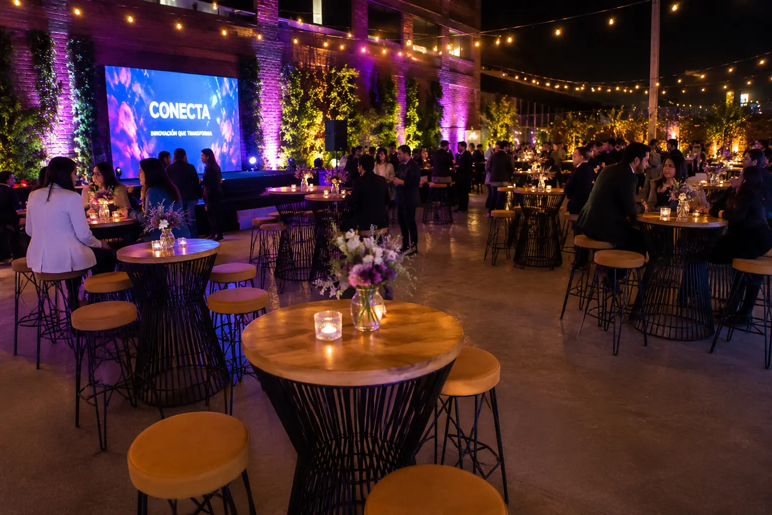 Mesas cóctel industriales con butacos en evento corporativo nocturno