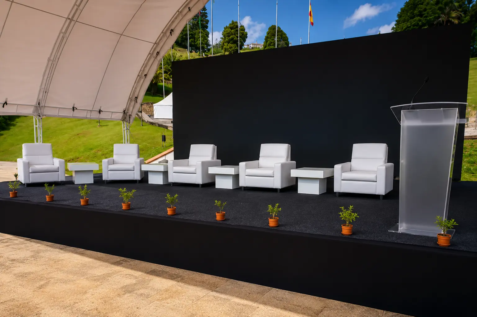 Tarima con poltronas blancas y atril para panel de lanzamiento al aire libre